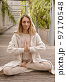 A woman meditates in the park 97170548