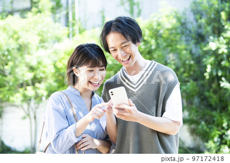 スマホで検索する若い夫婦 97172418