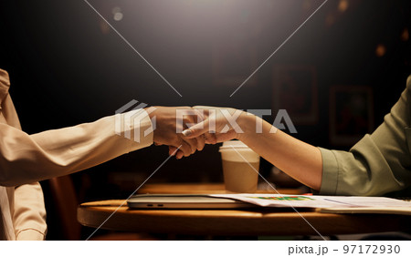 Two Businesswoman shaking hands as sign of successful negotiations. 97172930