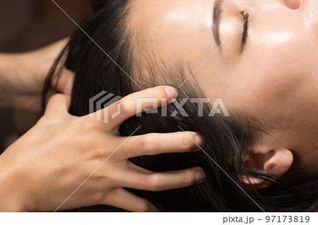 女性はヘッドマッサージを受けている。 女性はヘッドマッサージを受けている。 97173819