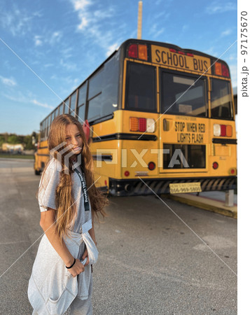 Beautiful teen girl getting on school bus 97175670