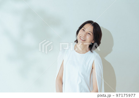 夏の葉陰で笑うミドル女性 97175977