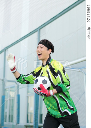 サッカーボールをキャッチするゴールキーパーの男性 サッカーボールをキャッチするゴールキーパーの男性 97176962
