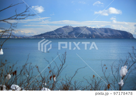 冬の北海道　雪が舞う中で対岸から函館山を望む 97178478