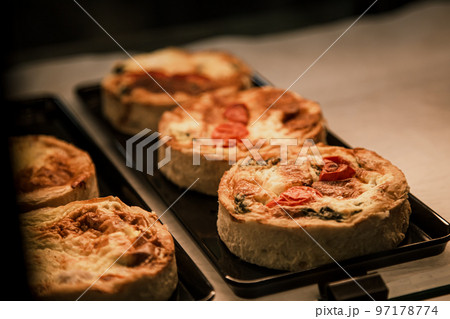 Small puff pies with vegetables and meat, quiches in a cafe window. Small puff pies with vegetables and meat, quiches in a cafe window. 97178774