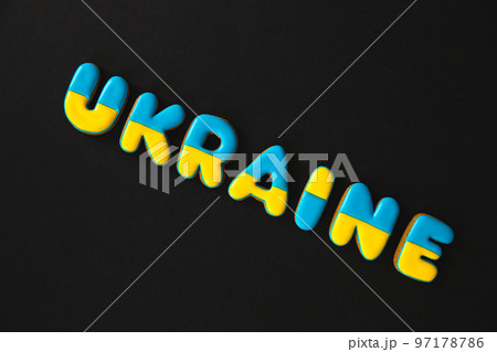 The word Ukraine on a black background, made with handmade gingerbread. The word Ukraine on a black background, made with handmade gingerbread. 97178786