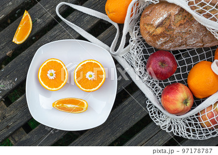 Fruits and bread in a shopping bag on a wooden background. Fruits and bread in a shopping bag on a wooden background. 97178787