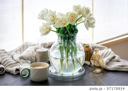 Home composition with a bouquet of tulips in a glass vase and candles. Home composition with a bouquet of tulips in a glass vase and candles. 97178934
