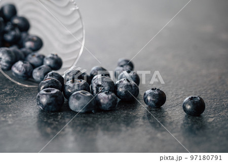 Macro photography, blueberries scattered on a dark surface. 97180791