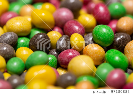 Peanuts covered with multicolored glaze, close up. 97180882
