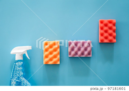 Glass cleaner spray and sponge on blue background, flat lay. Glass cleaner spray and sponge on blue background, flat lay. 97181601