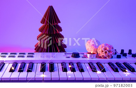 Christmas background with midi keyboard and holiday decor with neon lights. 97182003