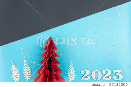 Christmas background with origami paper tree and number 2023, flat lay. Christmas background with origami paper tree and number 2023, flat lay. 97182009
