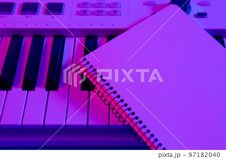 Close-up, notepad on musical keys in neon lighting. 97182040