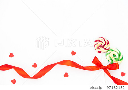 Two beautiful lollipops tied with a red ribbon in a bow on a white isolated. 97182182