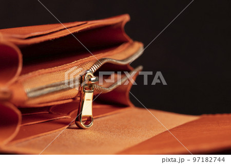 Part of a leather wallet and purse on a black background. 97182744