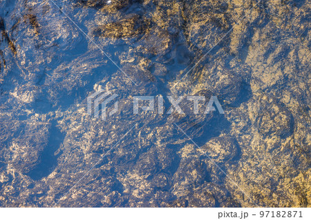 Bluish sheen of clear water and seaweed at the bottom of the creek Bluish sheen of clear water and seaweed at the bottom of the creek 97182871