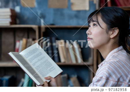 シックな部屋でのんびりと読書する若い女性 97182958