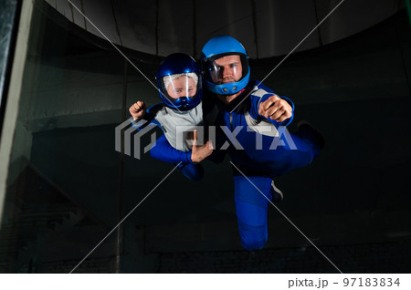 A man teaches a boy to fly in a wind tunnel. Lack of gravity. 97183834
