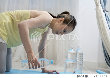 ペットボトルダンベルでトレーニングする女性 ペットボトルダンベルでトレーニングする女性 97185574