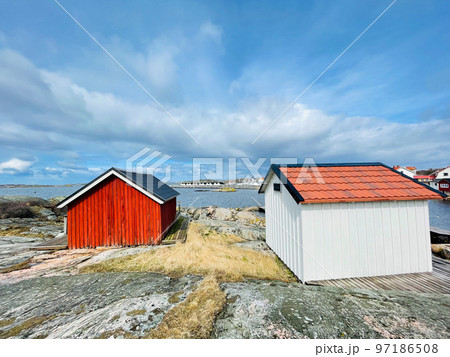A view of red wooden houses on Vrango Archipelago island . A view of red wooden houses on Vrango Archipelago island . 97186508