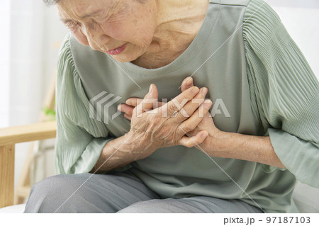 家で胸が痛む高齢者女性 97187103