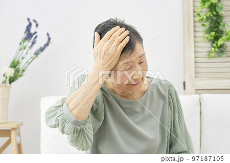 家で頭痛がする高齢者女性 97187105