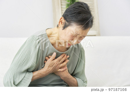 家で胸が痛む高齢者女性 97187108