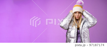 Upset gloomy complaining blond girlfriend whining standing upset disappointed sulking offended pulling hat forehead look offended unhappy wearing stylish glittering jacket unwilling go outside cold Upset gloomy complaining blond girlfriend whining standing upset disappointed sulking offended pulling hat forehead look offended unhappy wearing stylish glittering jacket unwilling go outside cold 97187174