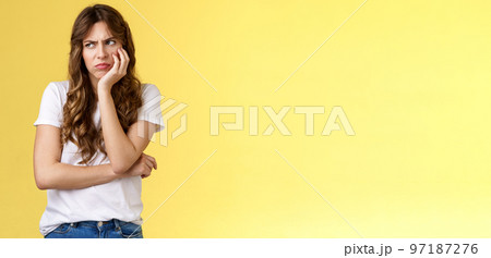 Jealous upset angry moody girlfriend lean palm smirking frowning bothered gloomy look aside turn left dismay sitting lonely offended overthinking drama queen stand yellow background 97187276