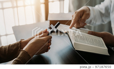 Asian men and women hands praying to god with the bible. Pray for god blessing. Religious beliefs Christian life crisis prayer to god. Asian men and women hands praying to god with the bible. Pray for god blessing. Religious beliefs Christian life crisis prayer to god. 97187650