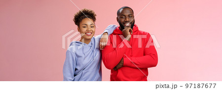 Romantic couple best friends standing pink background girl leaning boyfriend shoulder smiling broadly feel love respect each other working team standing pleased delighted friendly look camera 97187677