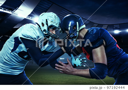 Start of competition. Two american football players in uniform standing face to face at the stadium with flashlights. Concept of sport, motion 97192444