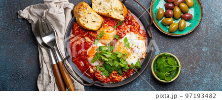 Middle Eastern and Maghrebi healthy dish Shakshouka made of eggs and tomato sauce served in pan Middle Eastern and Maghrebi healthy dish Shakshouka made of eggs and tomato sauce served in pan 97193482