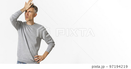 Image of frustrated and distressed middle-aged man, making facepalm and exhaling disappointed, standing over white background Image of frustrated and distressed middle-aged man, making facepalm and exhaling disappointed, standing over white background 97194219