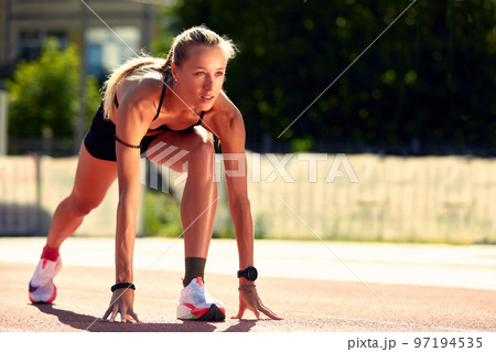 Woman getting ready to start on Stadium - summer outdoors training. Woman getting ready to start on Stadium - summer outdoors training. 97194535