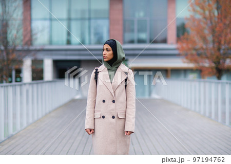 Young multiracial woman standing in a city bridge. Young multiracial woman standing in a city bridge. 97194762