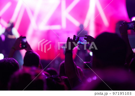 Hand with a phone records live music festival. People taking photographs with smart phone during concert. Hand with a phone records live music festival. People taking photographs with smart phone during concert. 97195103