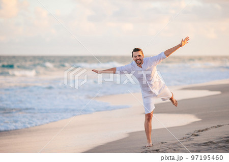 Young man in white on the beach having fun Young man in white on the beach having fun 97195460