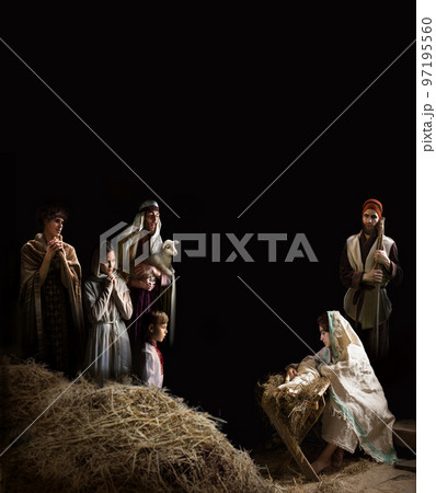 Mary sits in the stable near the manger with the baby Mary sits in the stable near the manger with the baby 97195560