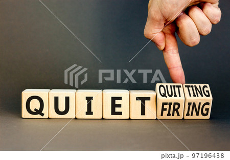 Quiet quitting or firing symbol. Concept words Quiet quitting Quiet firing on cubes. Businessman hand. Beautiful grey table grey background. Business quiet quitting or firing concept. Copy space. 97196438