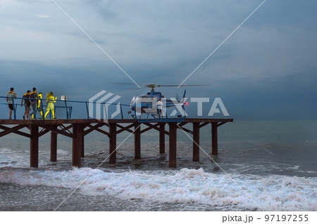 Rescuers head for a helicopter, in a gale. Night time 97197255