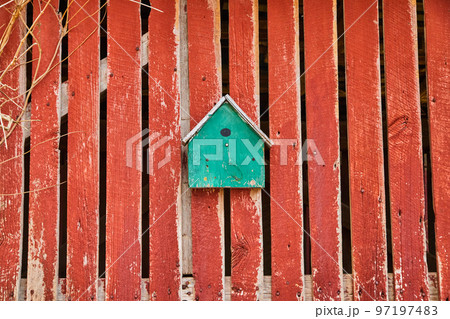 Turquoise birdhouse on faded red barnwood side Turquoise birdhouse on faded red barnwood side 97197483