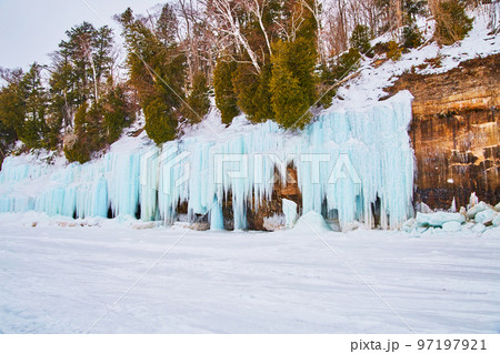 Icicles and ice formations blue frozen to rocky cliffs Icicles and ice formations blue frozen to rocky cliffs 97197921