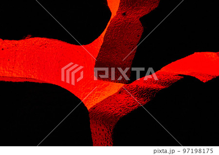 Volcano red glowing through textured rocks in display Volcano red glowing through textured rocks in display 97198175