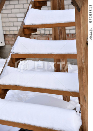 Wooden stairs at the house in the snow in winter. Beautiful staircase in the snow. Snow on the steps. 97198313