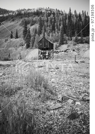 Black and white of desert field and mountains with mining building in distance Black and white of desert field and mountains with mining building in distance 97198506