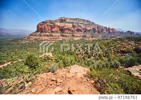 Large multicolored rocky outcropping rises above green trees Devils Bridge Large multicolored rocky outcropping rises above green trees Devils Bridge 97198761