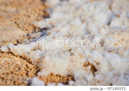 Macro of snow on sandy beach Macro of snow on sandy beach 97199352