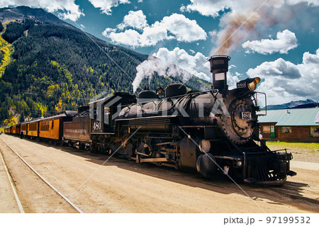 Vintage locomotive train up close in town against mountains Vintage locomotive train up close in town against mountains 97199532